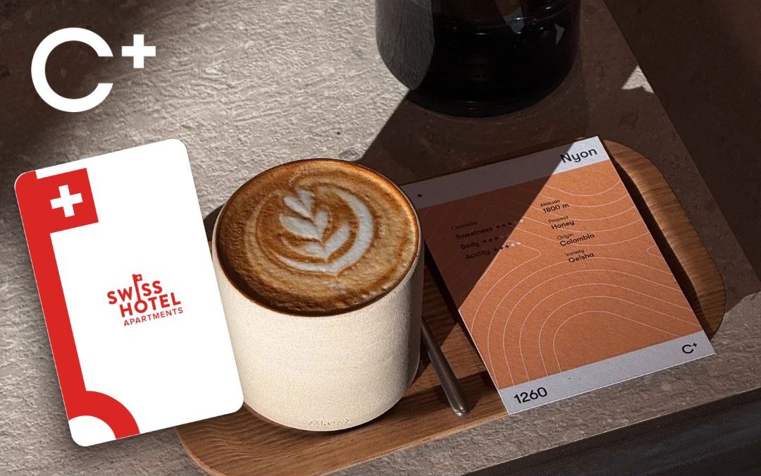 Swiss Hotel Apartments keycard next to a flat white and a C+ coffee card at C+