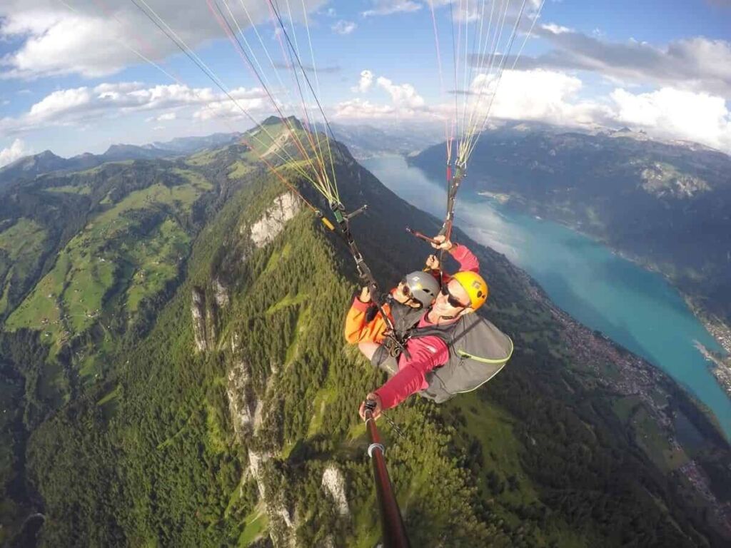 A paraglider flying over the mountains surrounding Interlaken