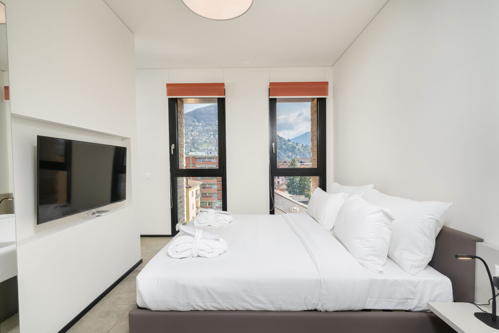 Bedroom and windows view in the one bedroom apartment in Lugano Swiss Hotel Apartments