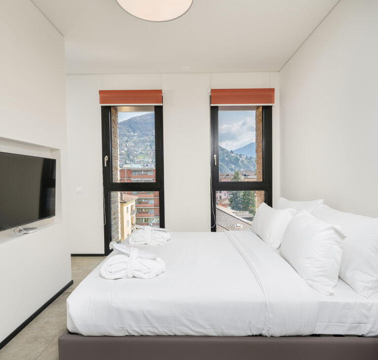 Bedroom and windows view in the one bedroom apartment in Lugano Swiss Hotel Apartments